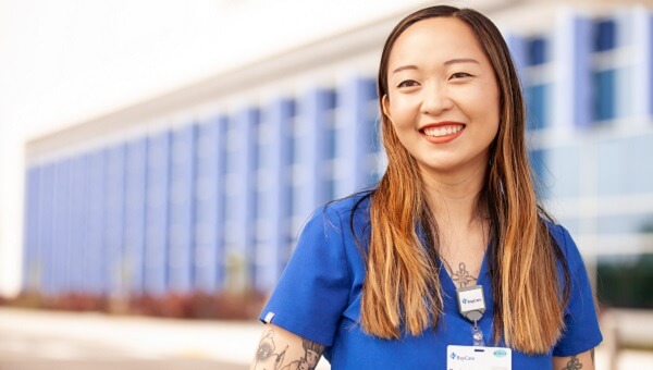 rachael barber smiling outside of hospital wearing blue scrubs